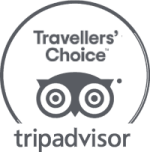 Tripadvisor logo featuring "Travellers' Choice" with an owl design in a circular emblem, in grayscale.