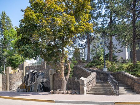 The image shows a stone staircase, trees, and a fountain in a park-like setting.