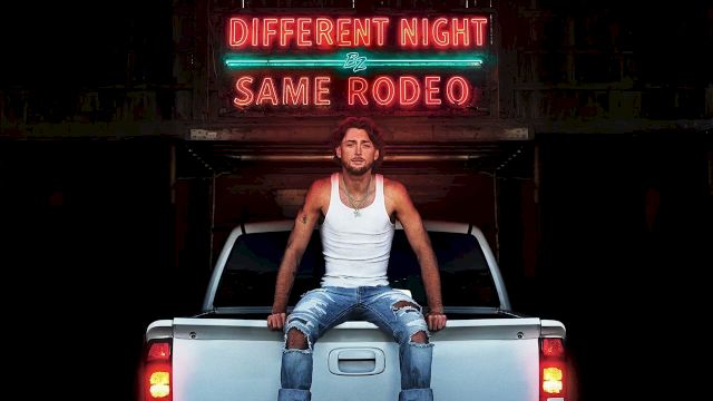 A man sits on the tailgate of a white pickup truck at night, under neon signs that read &ldquo;DIFFERENT NIGHT SAME RODEO.&rdquo;